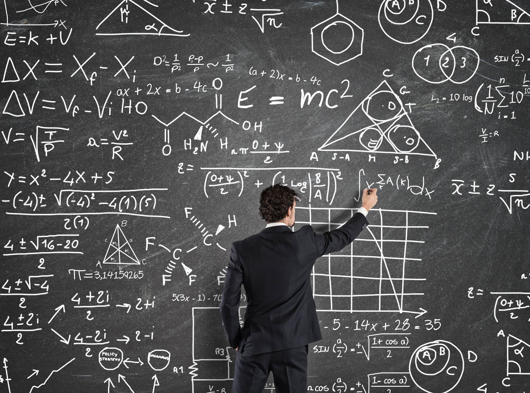 Businessman Solving Math Equations on Blackboard